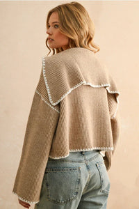 Beige stitch detailed sweater cardigan with ruffles, white trim, and tassels for women