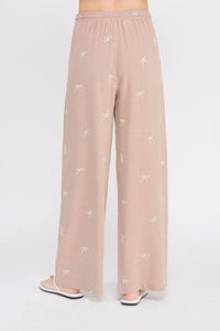 Beige embroidered linen pants with bow pattern and scallop trim for a stylish look