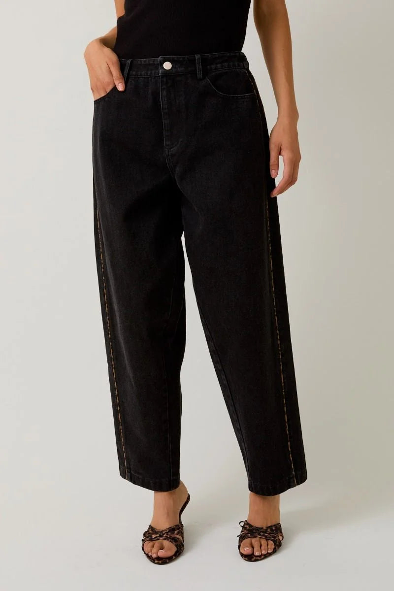 Black denim balloon pants with leopard print piping and contrast stitching for stylish appeal