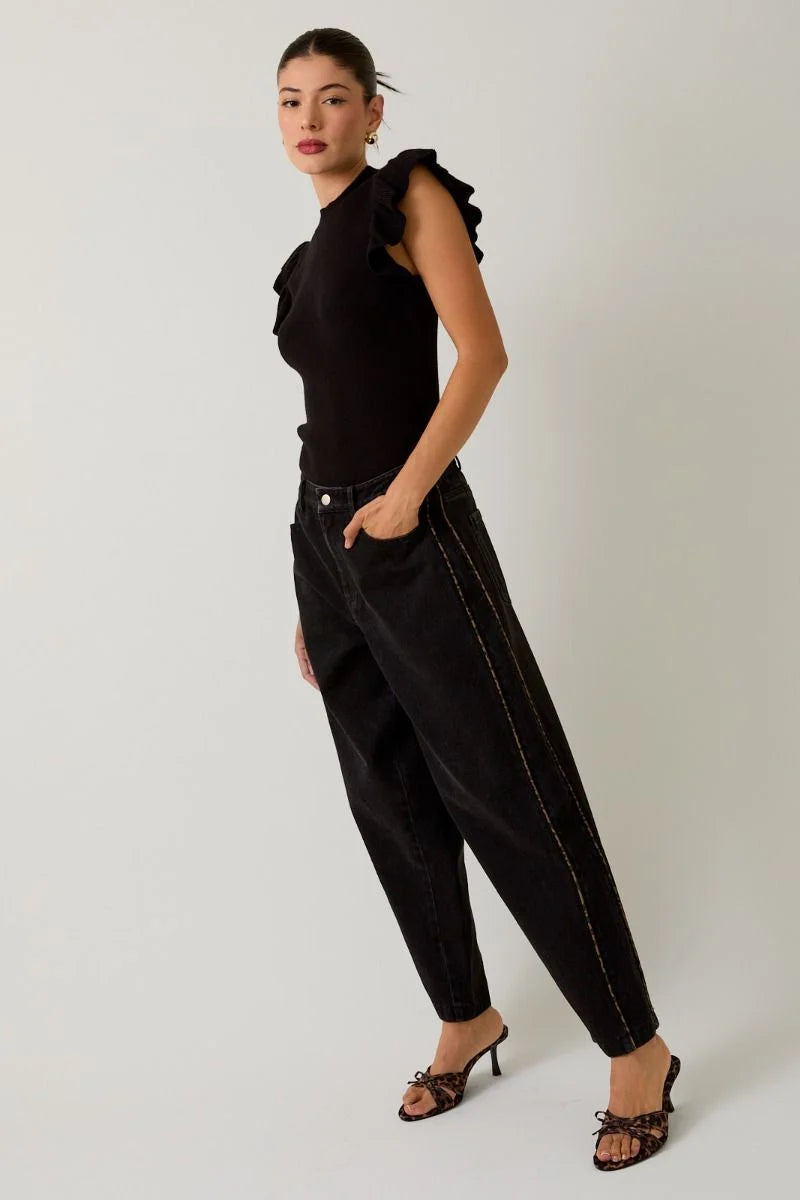 Black ruffled-sleeve top with high-waisted tapered pants featuring leopard print piping and open-toed heeled mules