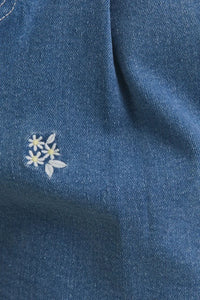 Blue denim fabric with floral embroidery on floral embroidered pleated denim shorts