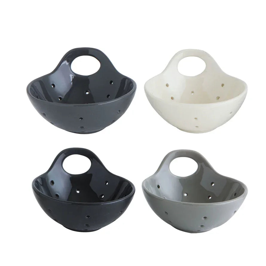 Bowl-shaped stoneware berry bowls in black, white, and gray with drainage holes