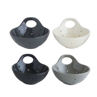 Bowl-shaped stoneware berry bowls in black, white, and gray with drainage holes