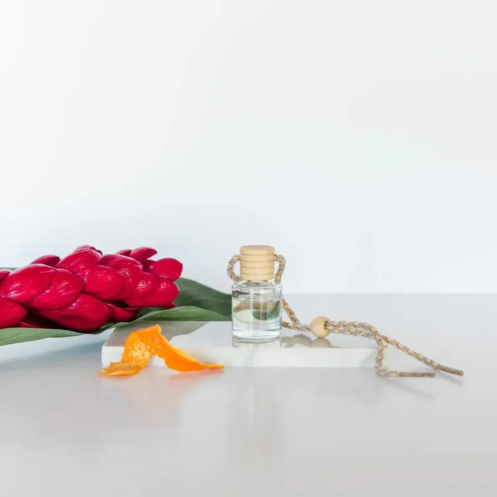 Car diffuser in clear glass bottle with wooden top and braided cord for women’s boho chic clothing