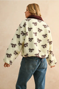 Cream-colored bow pattern sherpa jacket with maroon collar and button front