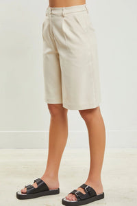 Cream-colored pleated wide leg half pants tailored for a sophisticated look