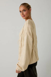 Cream-colored cable knit tie front cardigan with openwork design and drawstring hem