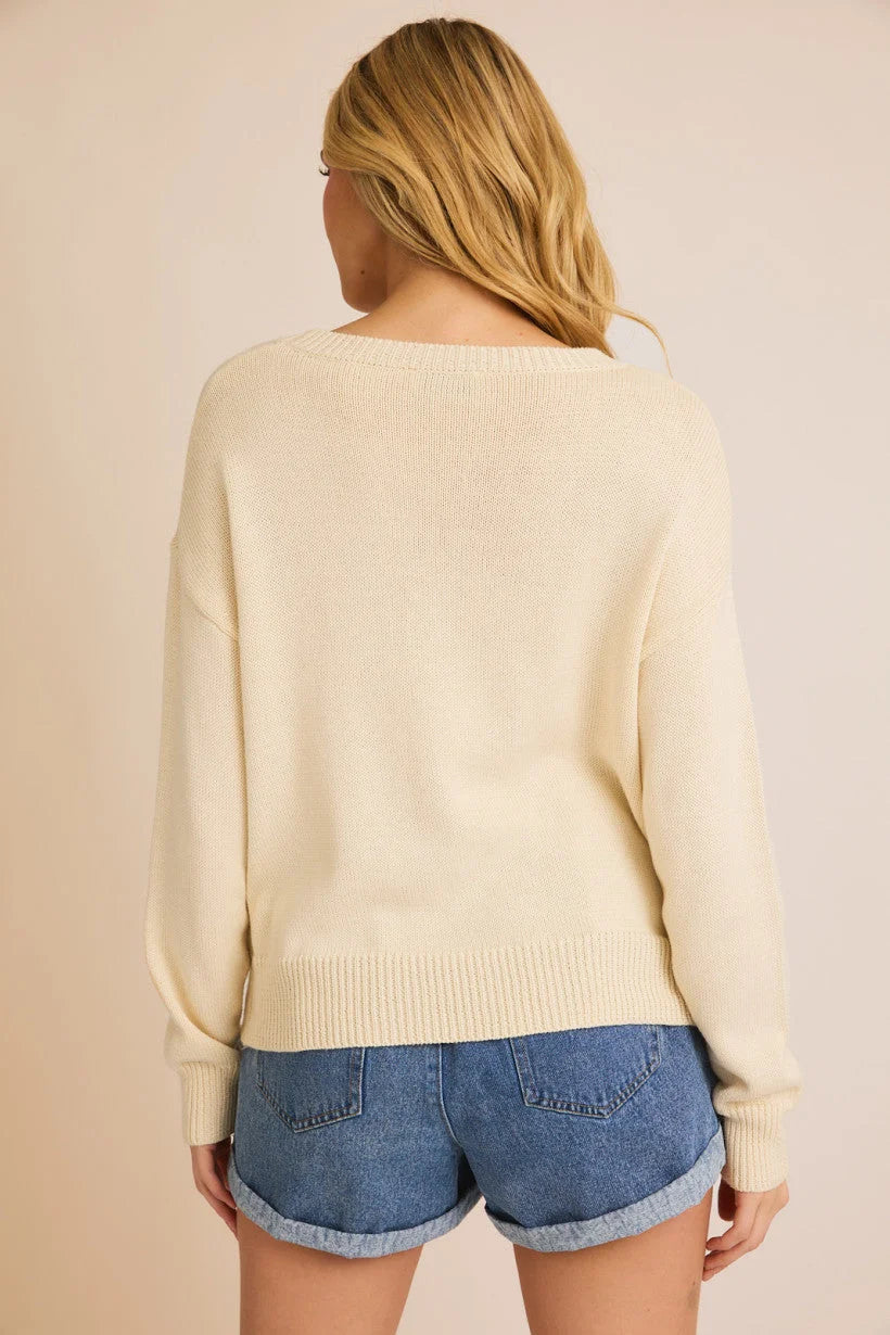 Cream-colored light weight sweater paired with denim shorts for a stylish salty vibes light look