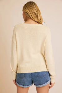 Cream-colored light weight sweater paired with denim shorts for a stylish salty vibes light look