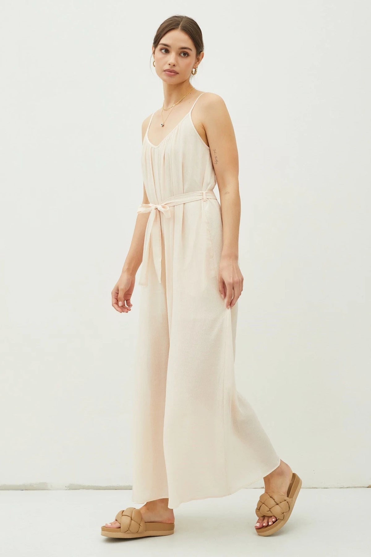 Cream-colored spaghetti strap jumpsuit with tie belt from Shop Daisy, perfect for women’s boho chic clothing