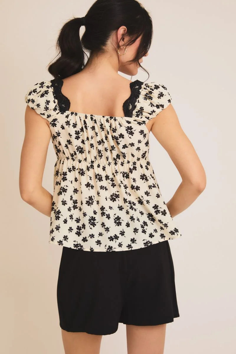 Floral print women’s top with black trim, ideal for women’s boho chic clothing at Shop Daisy