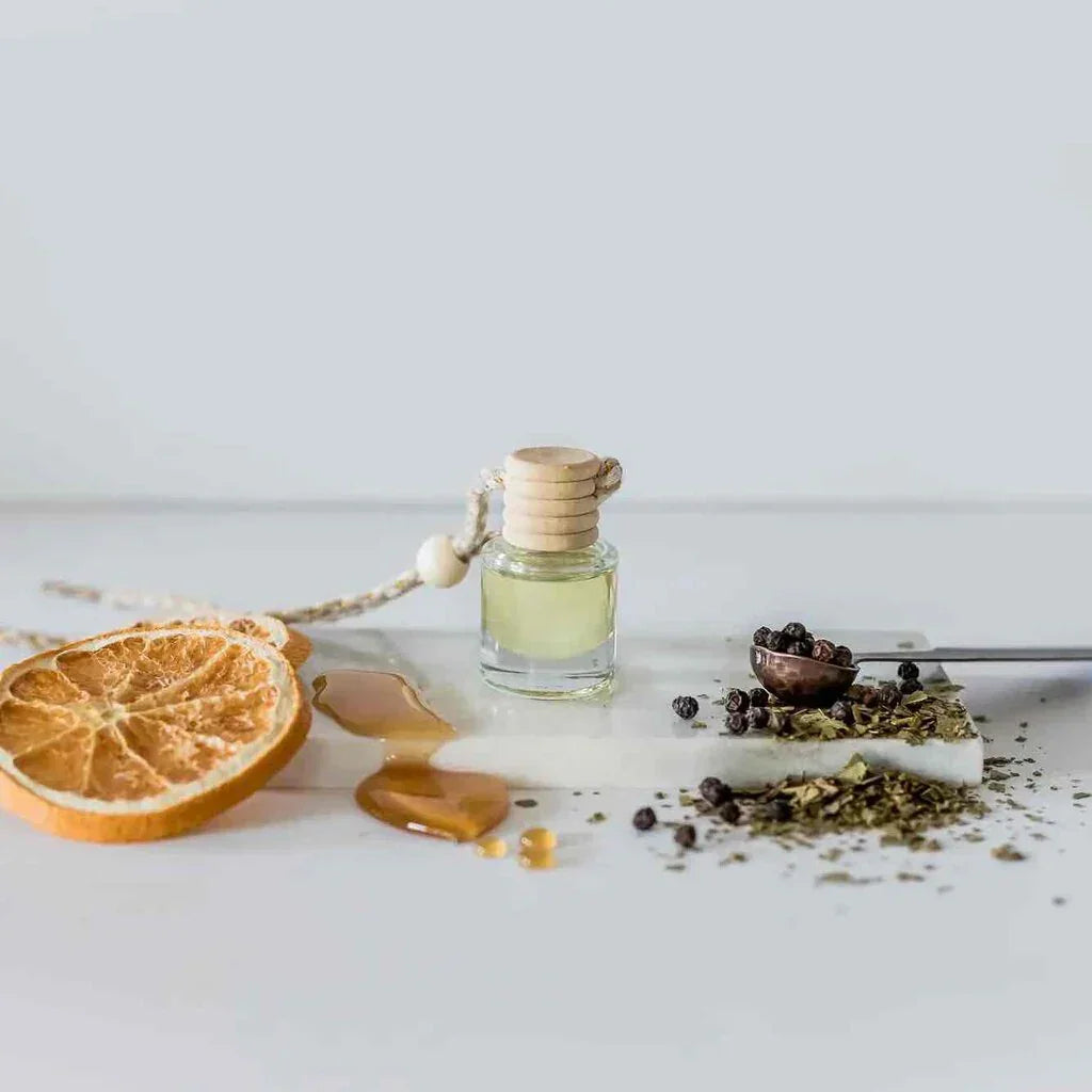 Car diffuser with light yellow liquid in a glass bottle, perfect for women’s boho chic clothing at Shop Daisy