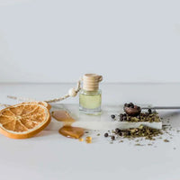 Car diffuser with light yellow liquid in a glass bottle, perfect for women’s boho chic clothing at Shop Daisy