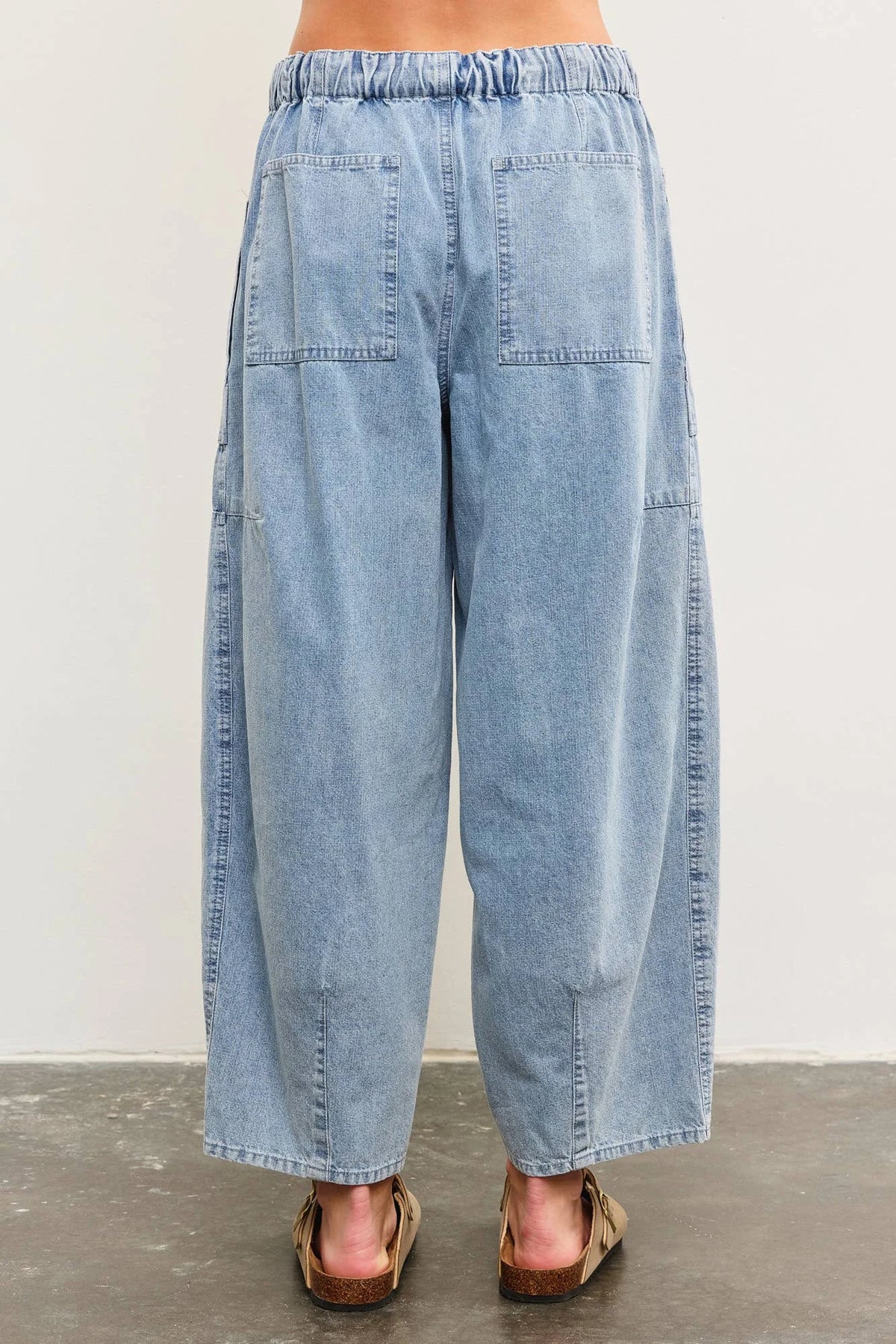 Light blue denim balloon pants featuring tied front and side seam detail for women’s boho chic clothing