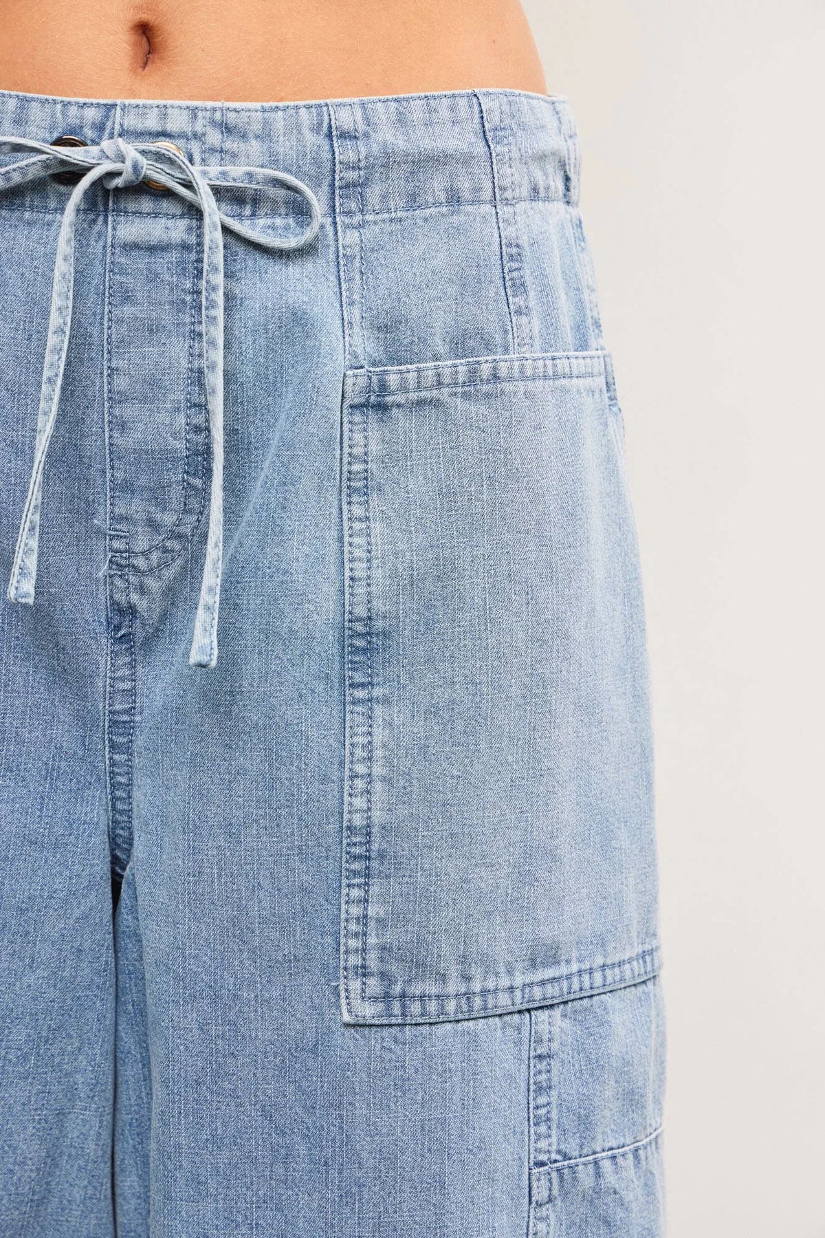 Light blue denim cargo pants from TIED FRONT SIDE SEAM DETAIL BALANCED BACK DENIM BALLOON PANTS, ideal for women’s boho chic clothing from Shop Daisy