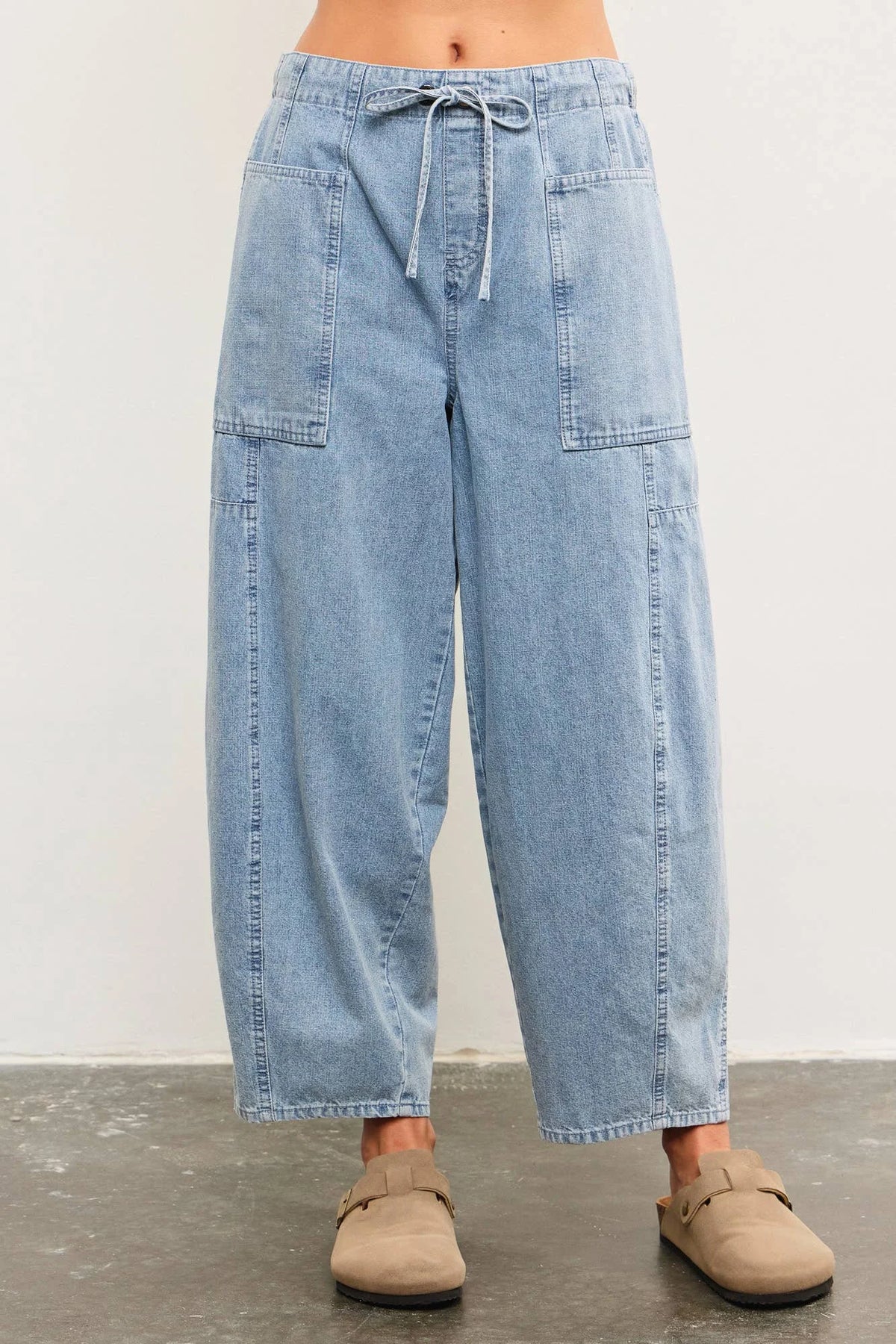 Light blue denim drawstring balloon pants from TIED FRONT SIDE SEAM DETAIL BANDED BACK collection, perfect for women’s boho chic clothing at Shop Daisy