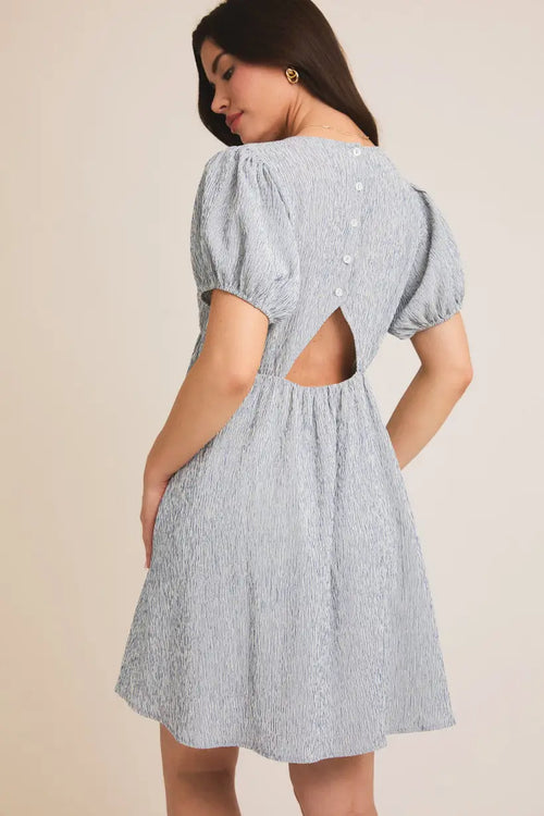 Light blue textured puff sleeve mini dress with back cutout, ideal for womenās boho chic clothing from Shop Daisy