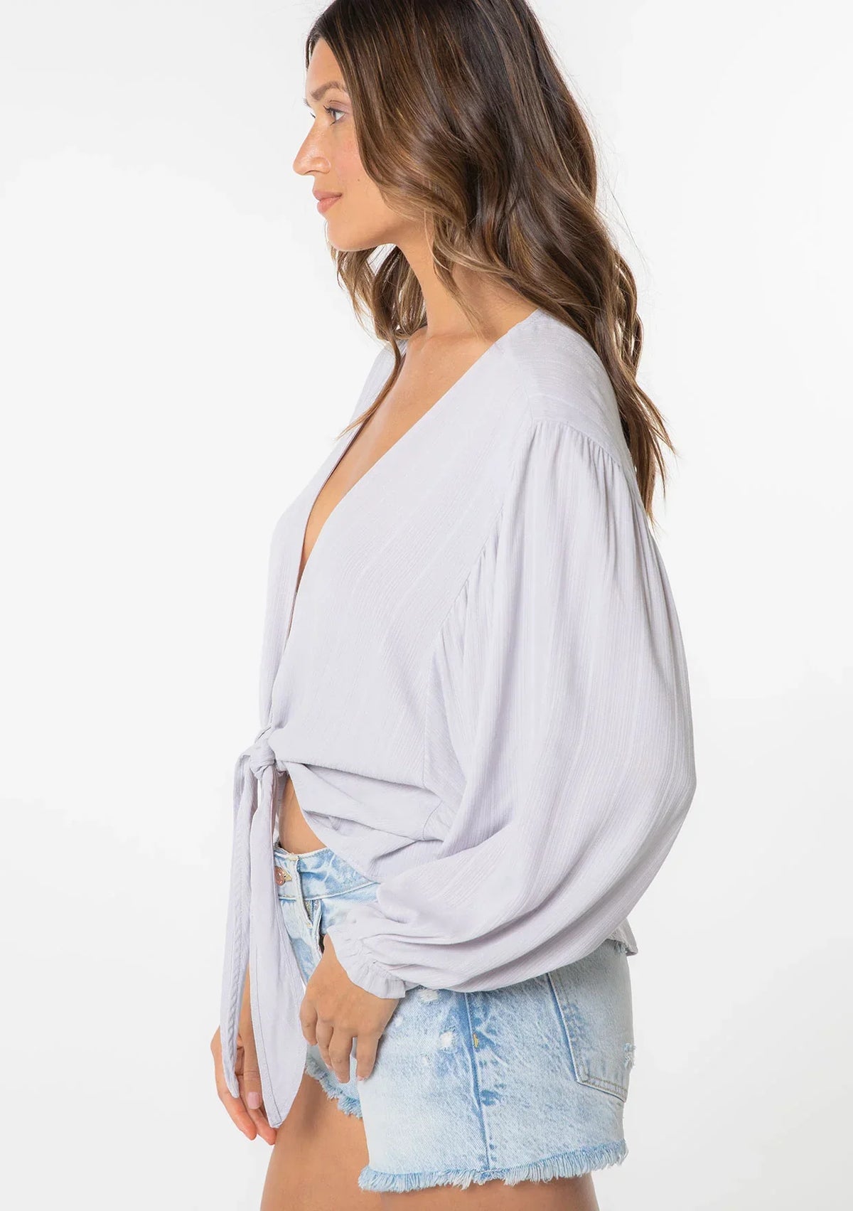 Jacquard stripe long sleeve wrap top with tie-front over light wash denim shorts