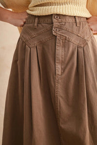 Long brown pleated detailed long skirt with angular waistband and button closure