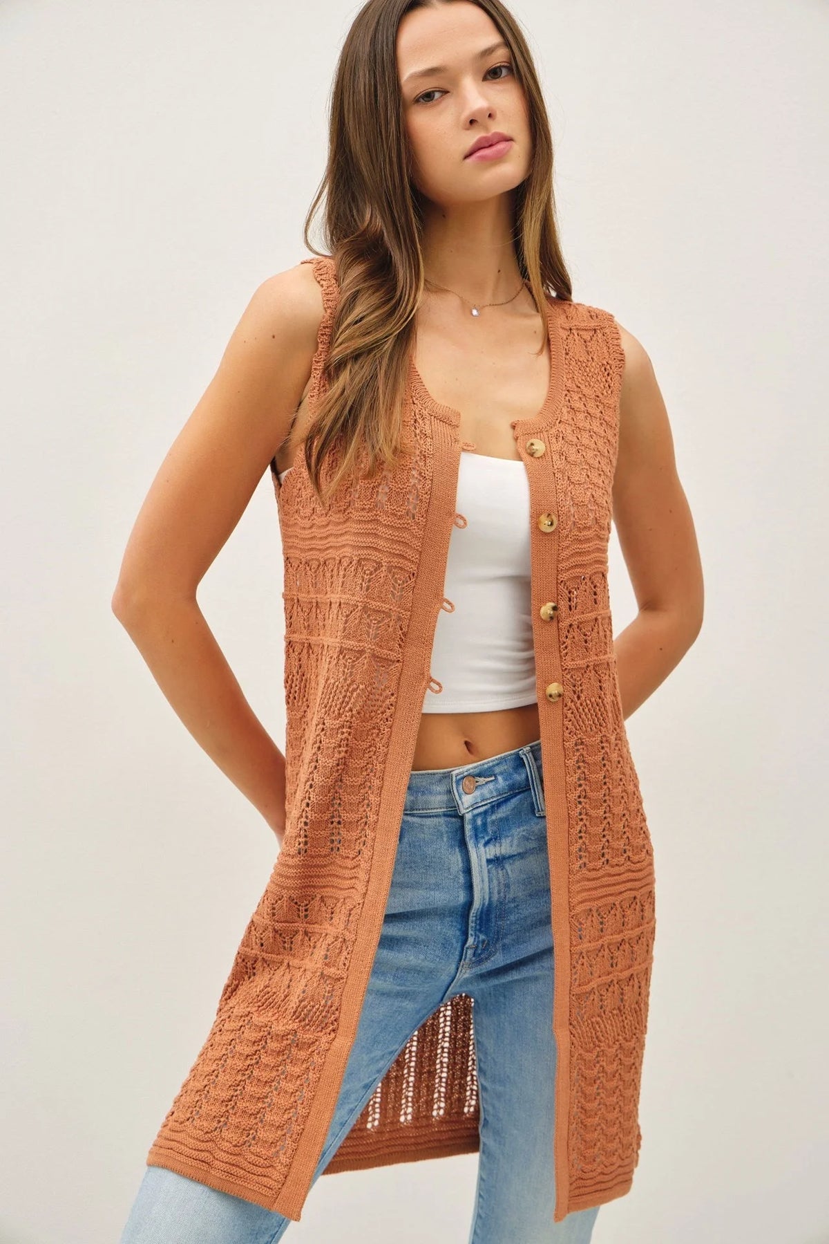 Crochet knit long sleeveless button-up vest from Shop Daisy for women’s boho chic clothing