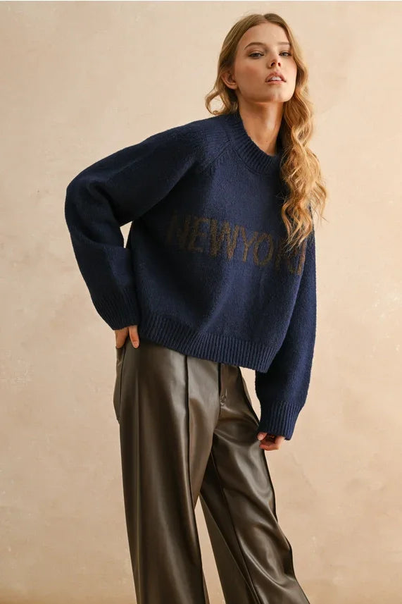Navy blue York Letter front sweater with brown accents and dark brown faux leather pants for women’s boho chic clothing at Shop Daisy