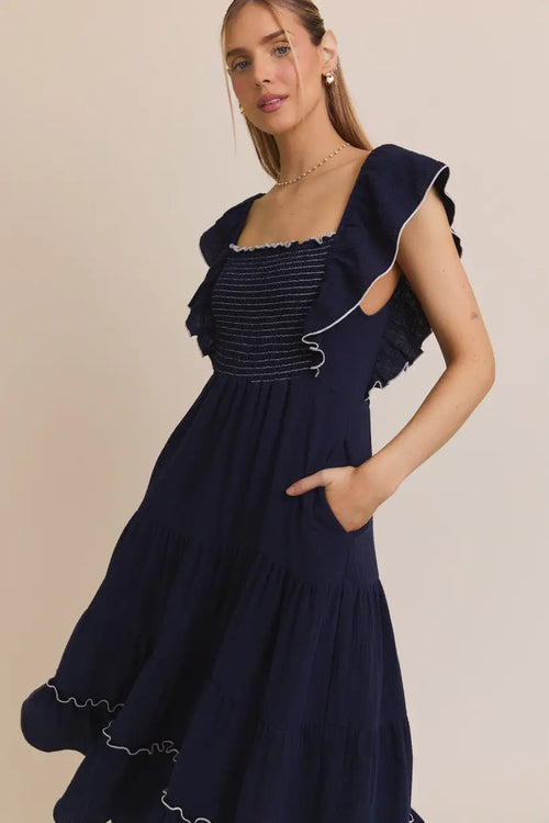 Navy blue square neck ruffle dress with white trim and ruffle sleeve smocking
