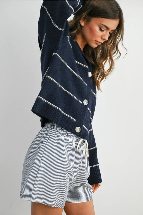 Navy blue striped collared cardigan with white buttons and drawstring hem