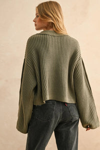 Olive green wide neck long sleeve sweater paired with dark wash straight-leg jeans