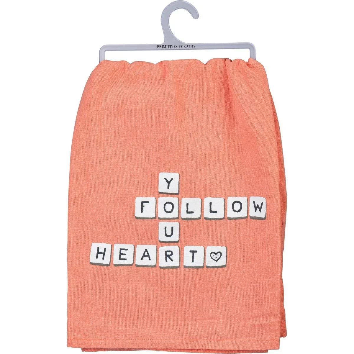 Peach dish towel with letter tiles spelling FOLLOW YOUR HEART in crossword style design