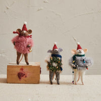 Pink fluffy wool mouse ornament with red hat and bell in fur sweater on wooden base