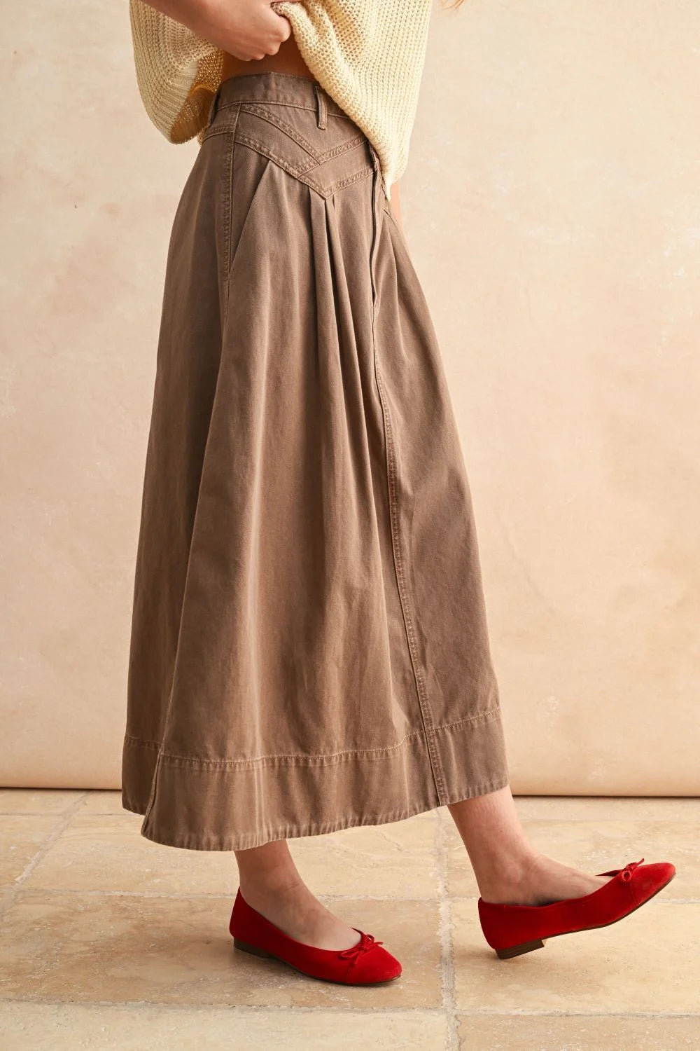 Mini pleat detailed long skirt in warm tan with red ballet flats for elegant style