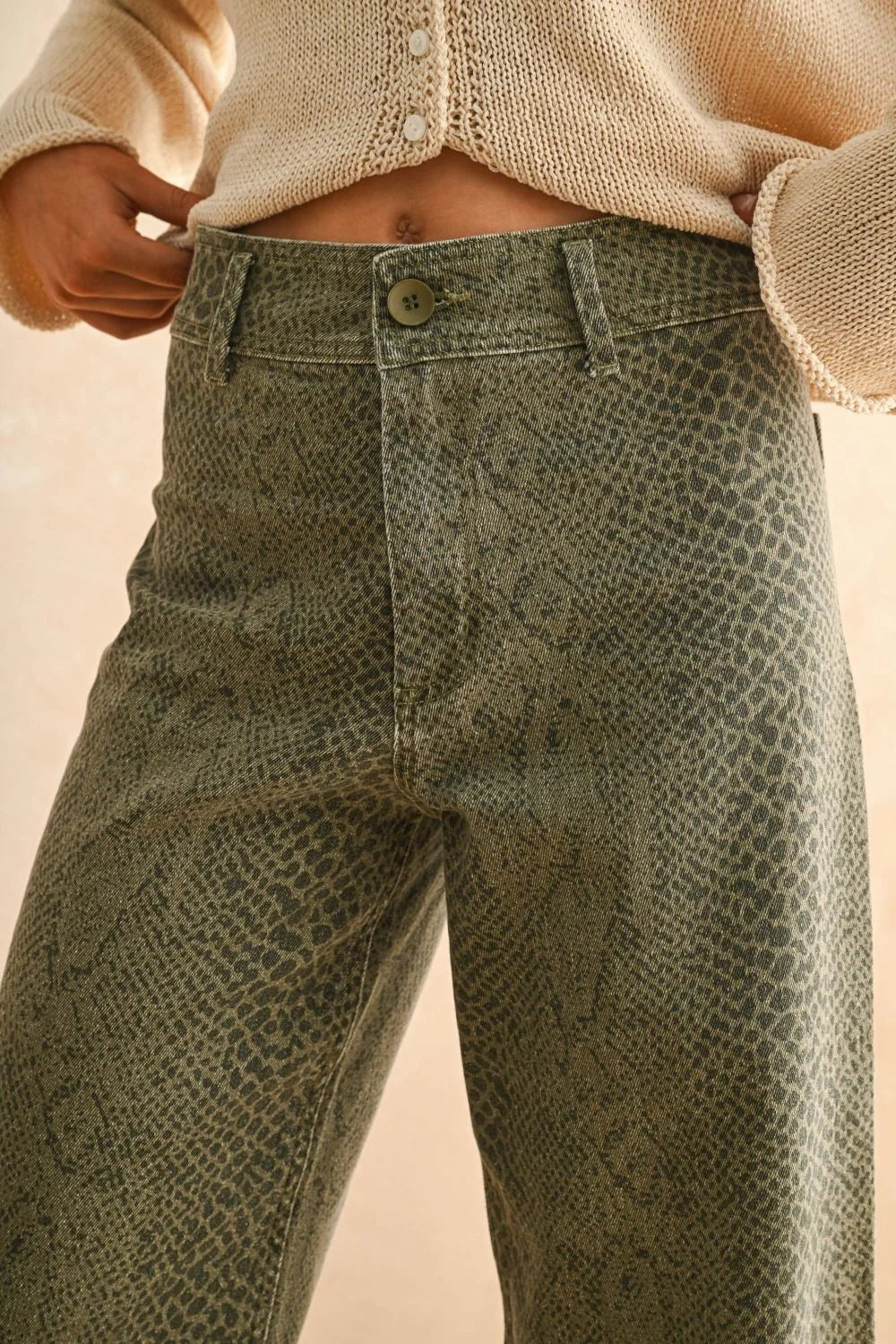 Woman wearing stylish snakeskin pants featuring a snake print pattern and wide-leg design