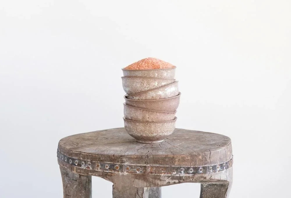 Stack of round macarons with pink filling in a stylish stoneware bowl by Shop Daisy