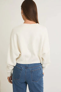 Back view of a cream-colored knit ROUND NECK MERRY CHRISTMAS SWEATER with blue jeans