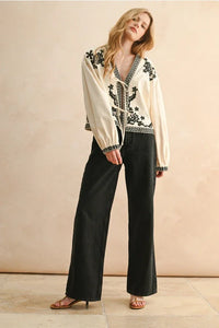 Floral patch detailed jacket with white embroidered blouse and black floral pants