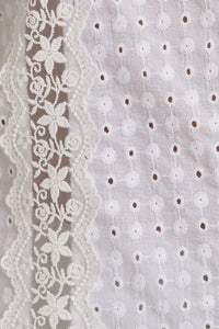 White eyelet fabric with floral lace trim showcases women’s boho chic clothing, shop Daisy