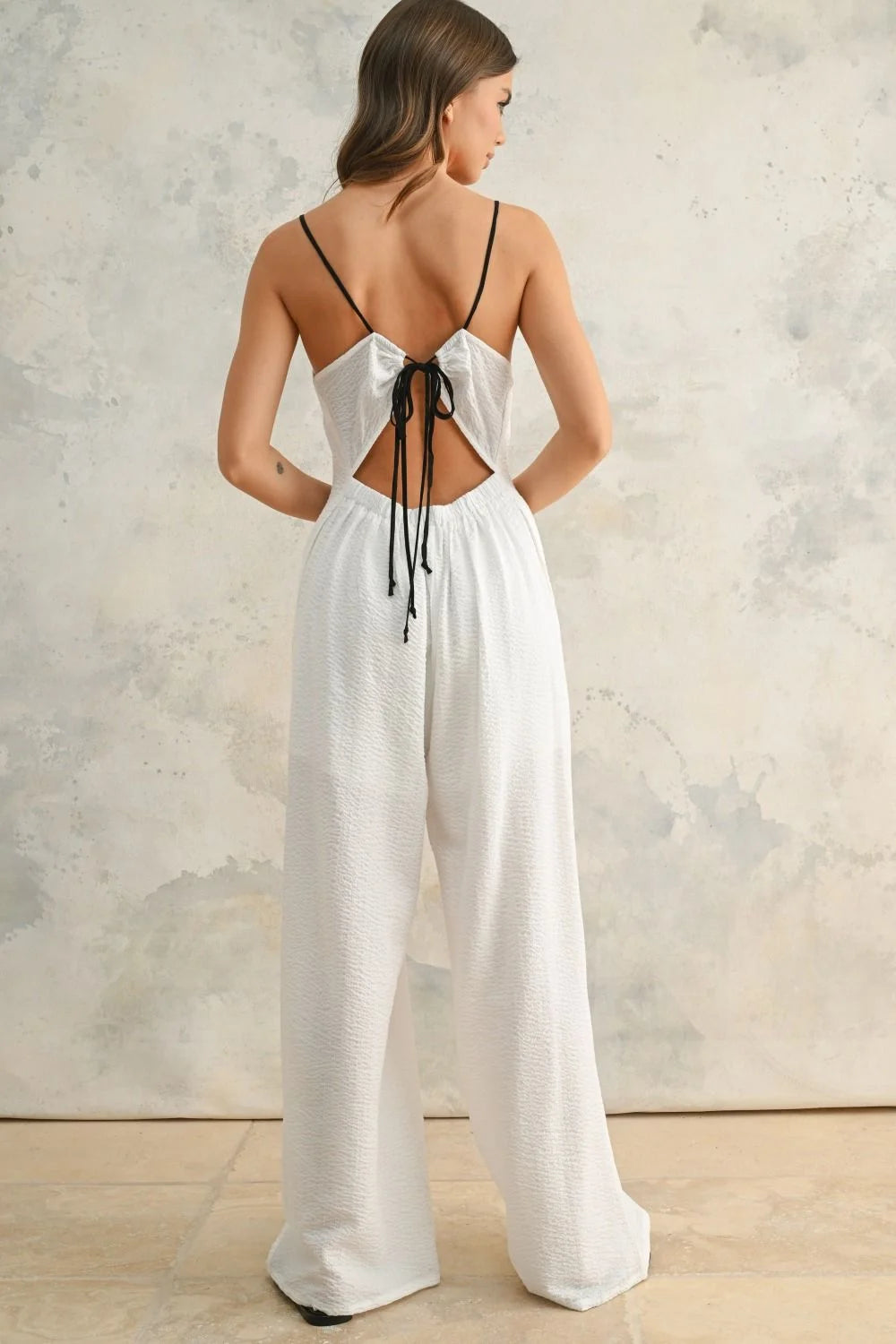 White open-back jumpsuit with contrast strap and spaghetti straps for stylish summer wear