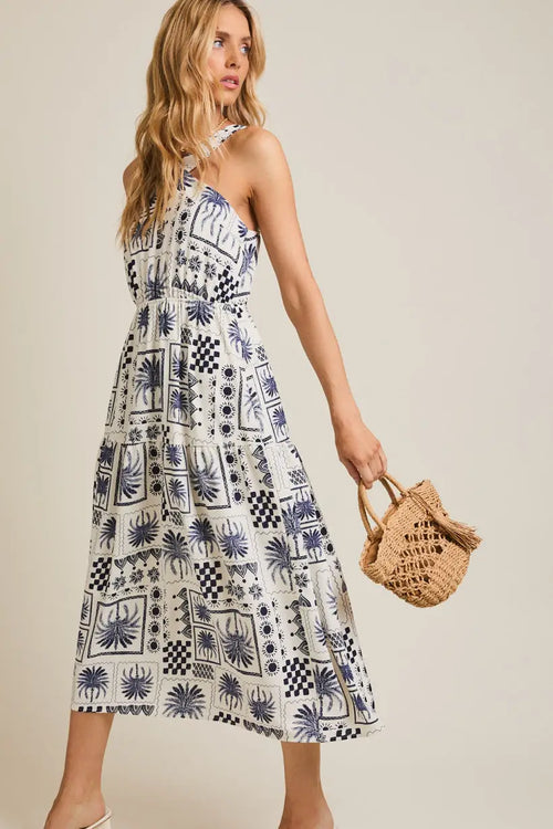 White halter neck abstract print dress featuring a stylish sleeveless design
