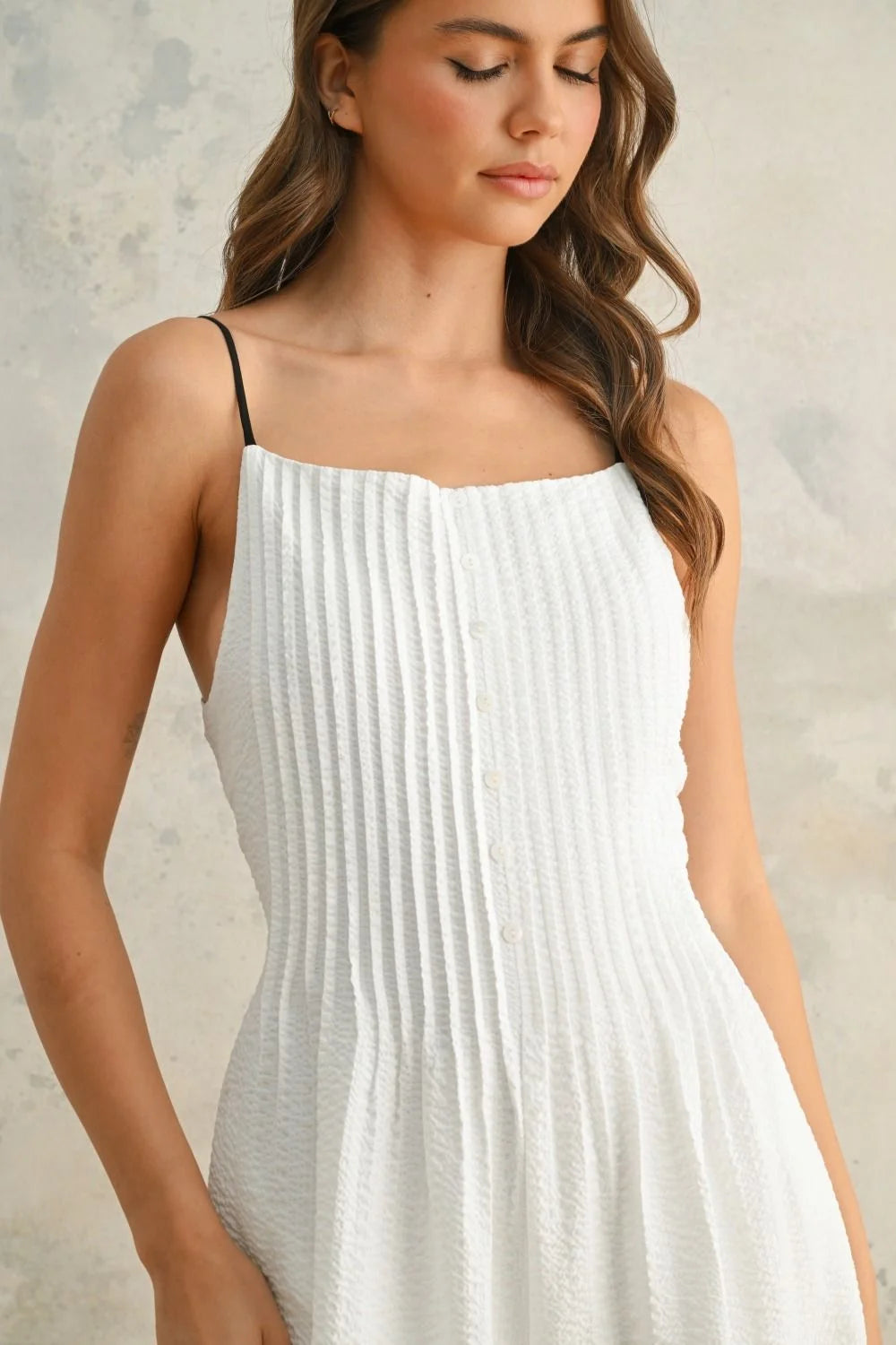 White pleated jumpsuit with spaghetti straps and stylish contrast strap detail