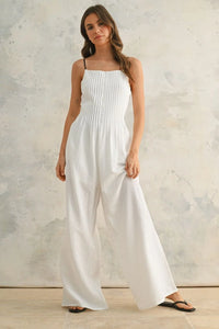 White wide-legged jumpsuit with contrast strap and spaghetti straps for a stylish look