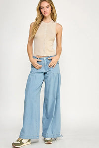 Woman in beige ribbed tank top and light blue wide-leg pants, perfect for women’s boho chic clothing
