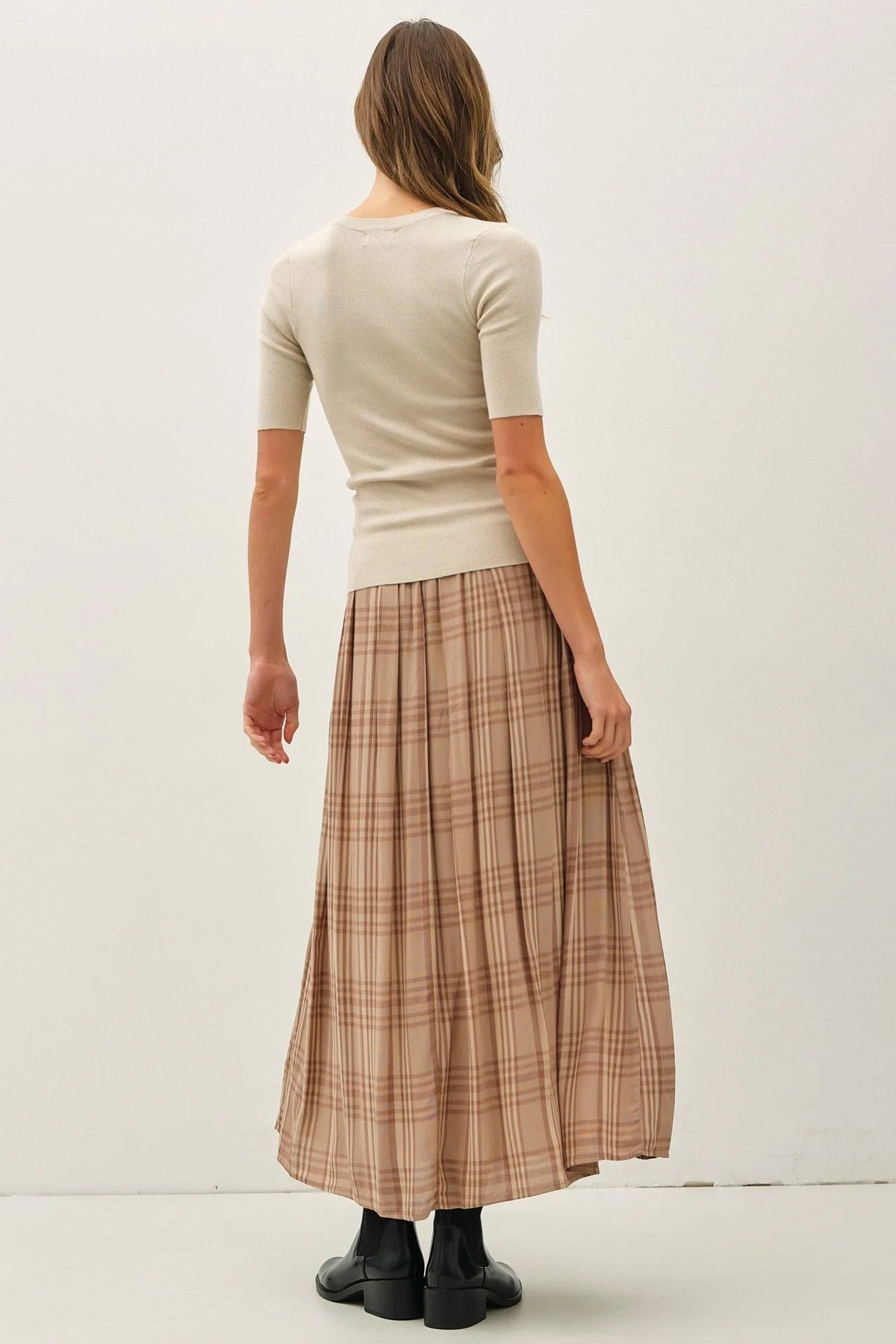 Woman wearing beige ribbed top and plaid printed pleats midi skirt for stylish look