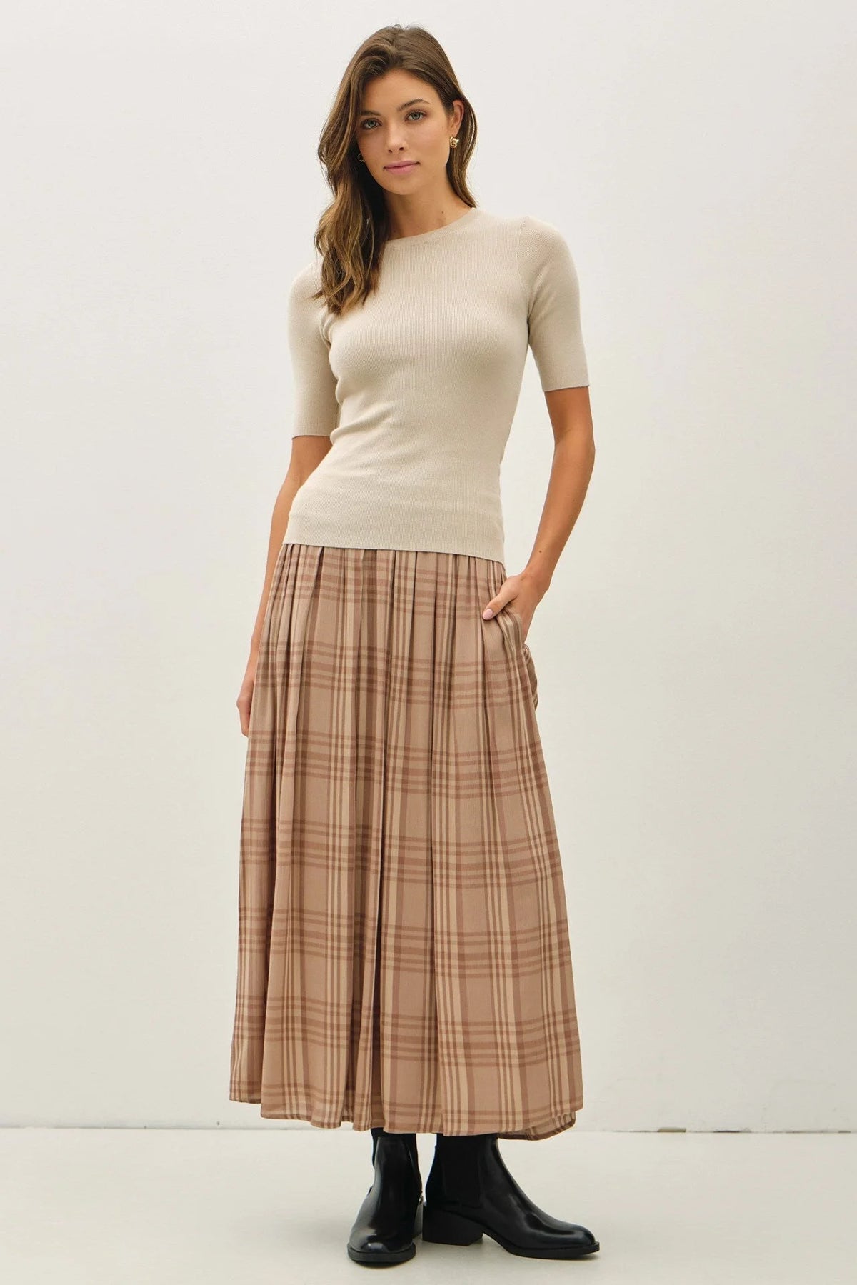 Woman wearing beige top and plaid printed pleats midi skirt, stylish pleats midi skirt