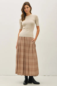 Woman wearing beige top and plaid printed pleats midi skirt, stylish pleats midi skirt