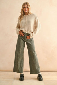 Woman wearing beige sweater and snakeskin snake print pants in a stylish outfit