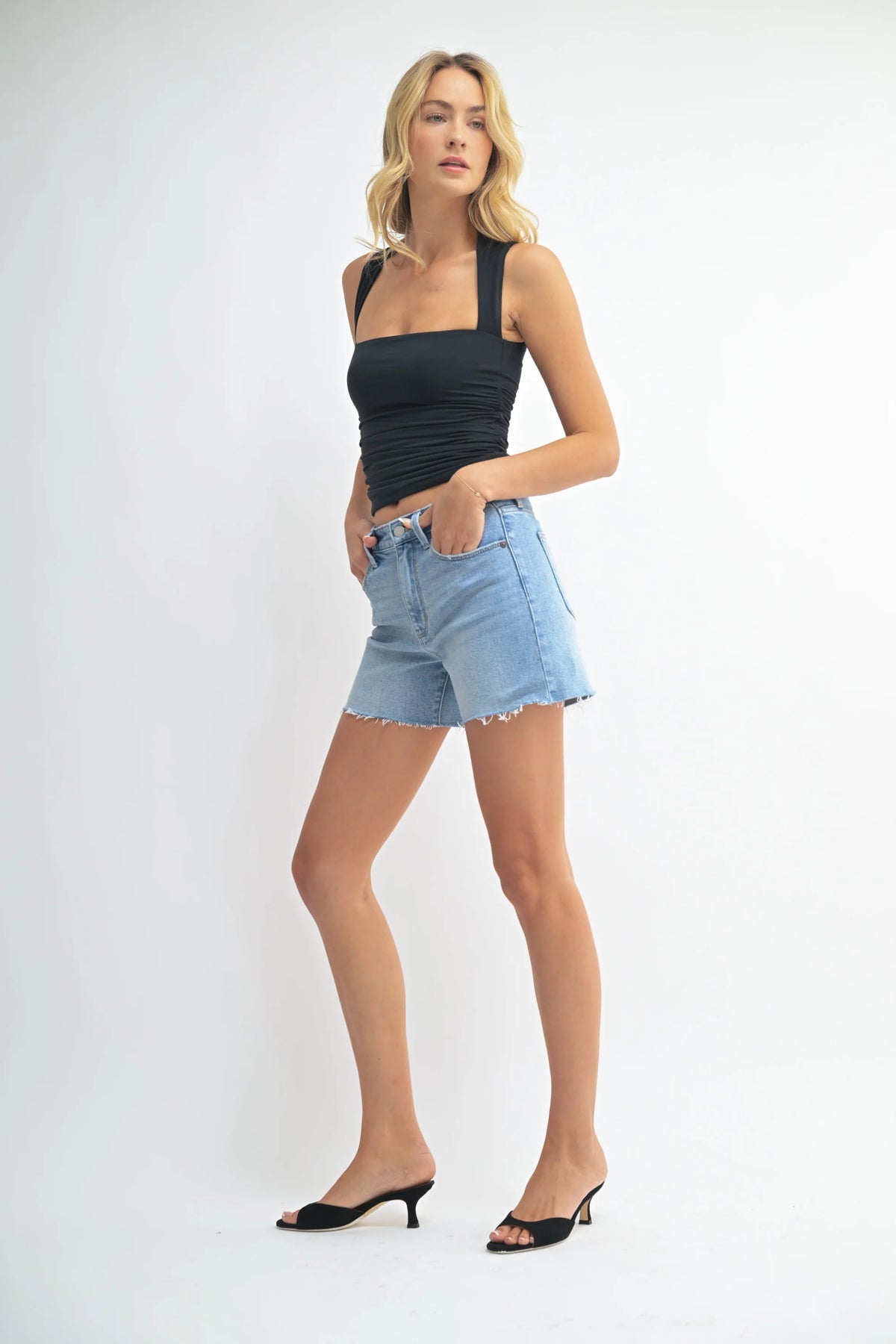 Woman in black top and denim longer length walking shorts for stylish summer wear