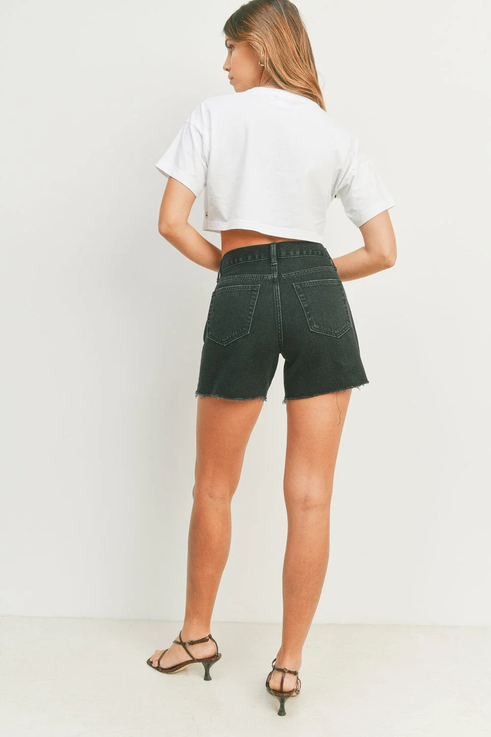 Woman wearing black denim shorts from SUMMER BOYFRIEND SHORT, perfect for womens boho clothes