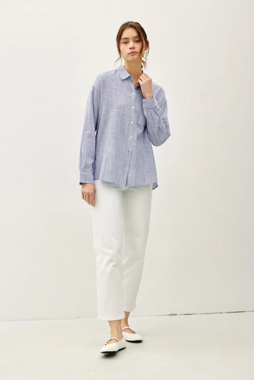 Woman in a blue striped PINSTRIPE BUTTON DOWN SHIRT, perfect for womenās boho chic clothing at Shop Daisy