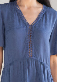 Woman wearing a blue floral jacquard airy short peplum blouse with crochet trim