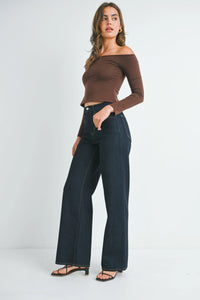 Woman wearing high rise relaxed wide leg denim jeans with brown off-the-shoulder top